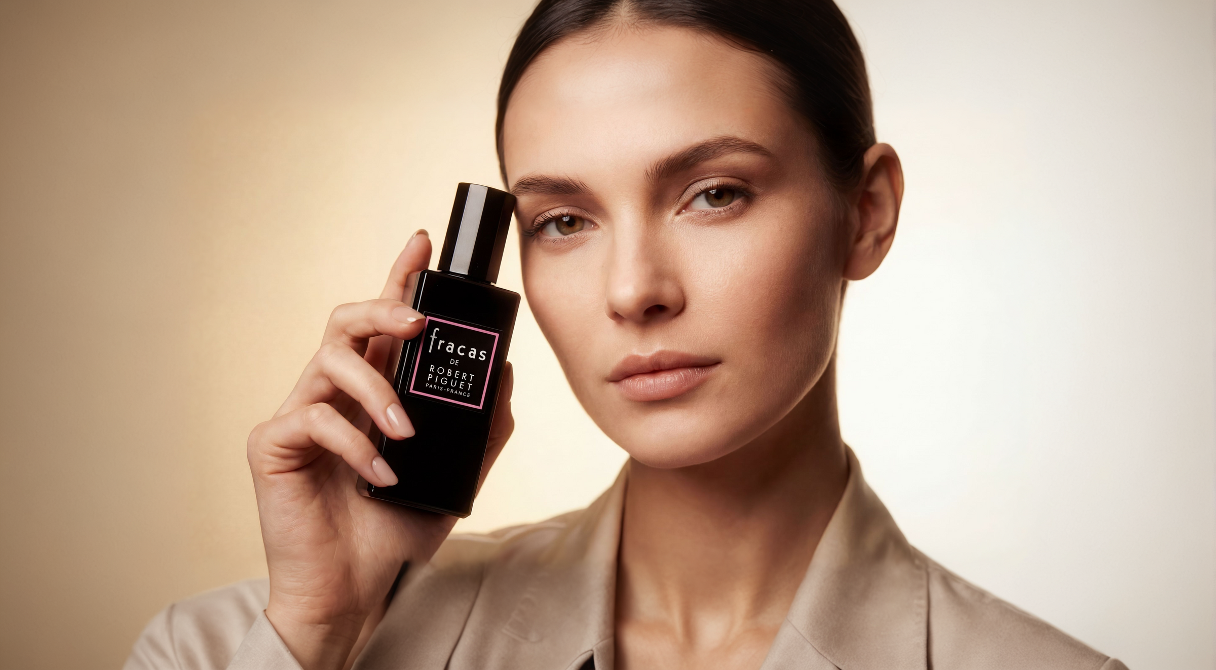 Woman holding Fracas perfume bottle